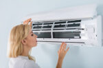 Woman looking into AC unit
