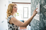 Woman adjusting thermostat