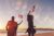 Family waving american flags while walking on the beach