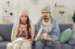 Man and woman holding coffee mugs in the cold.