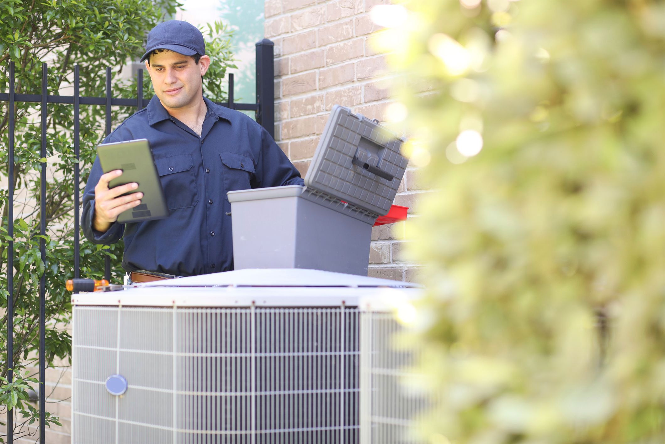 an HVAC technician working on an air conditioner
