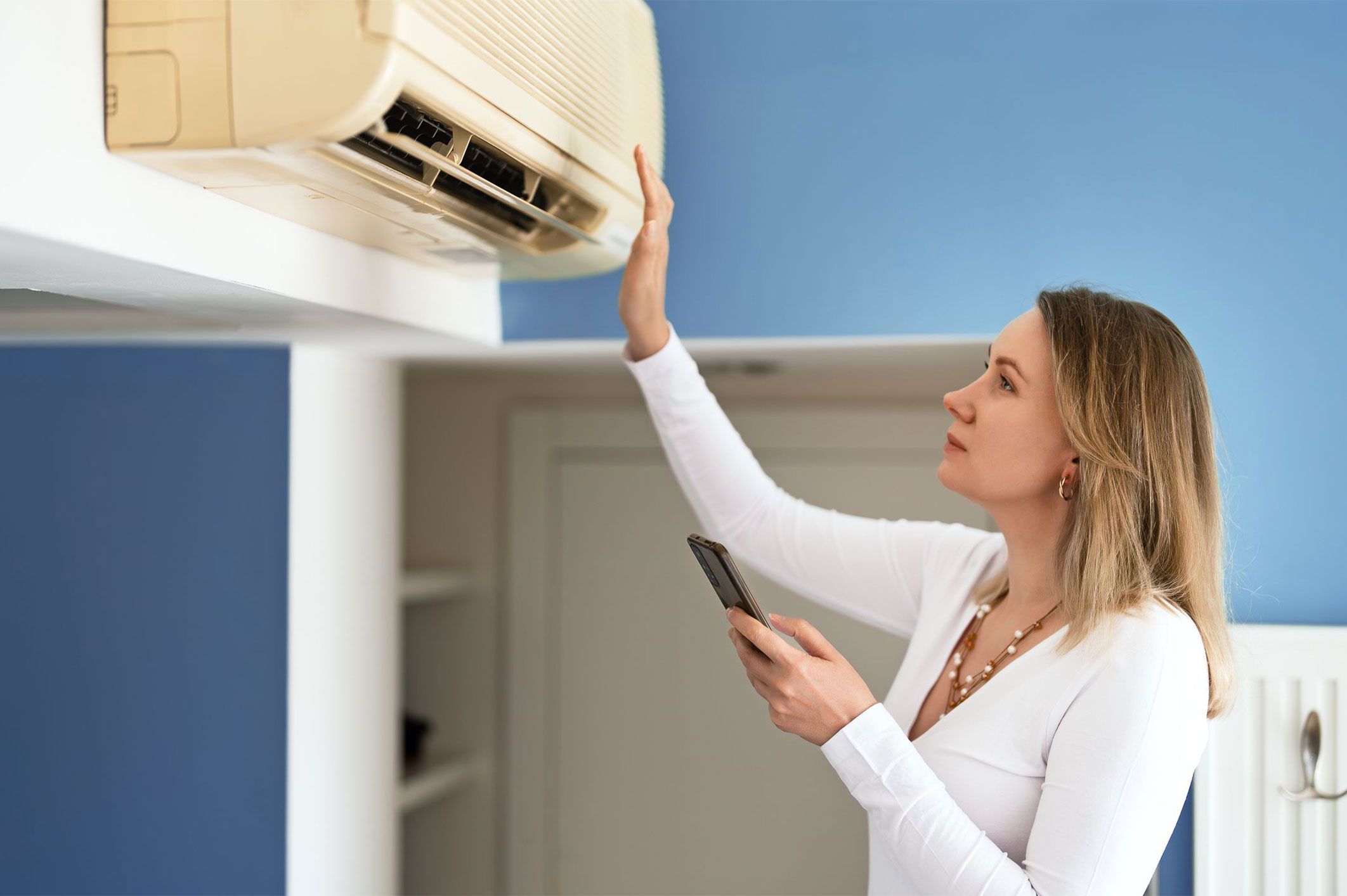 a woman inspecting a broken AC system
