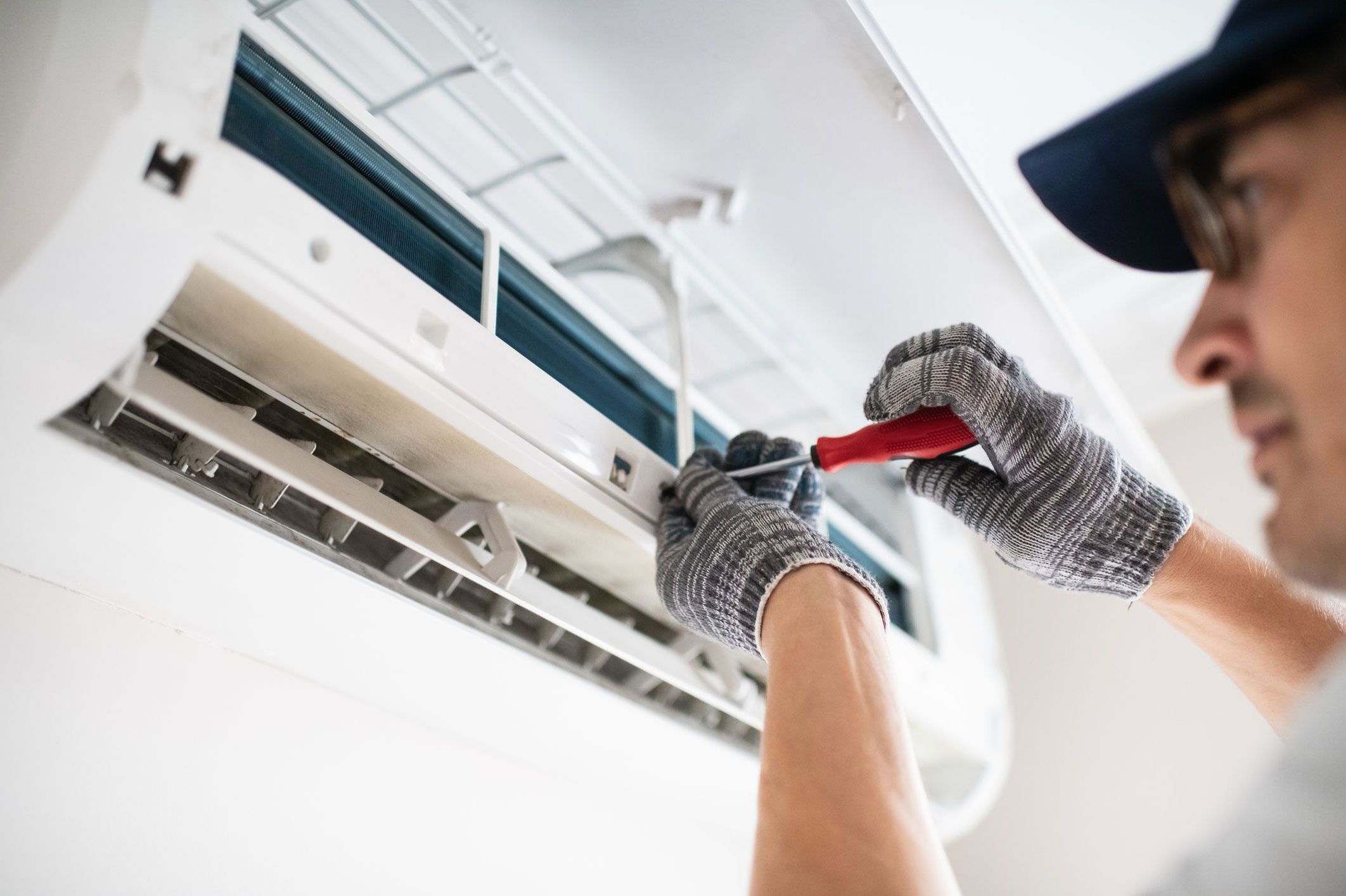 an HVAC technician repairing an air conditioner
